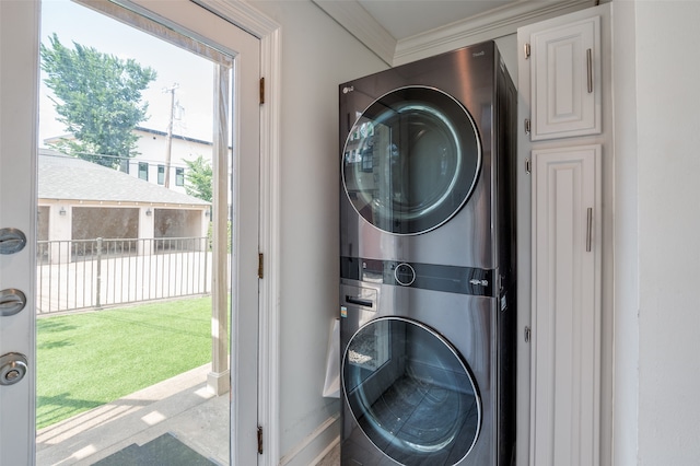 washroom with stacked washer / drying machine and crown molding