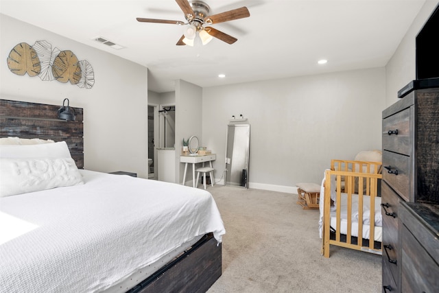 carpeted bedroom with a barn door and ceiling fan