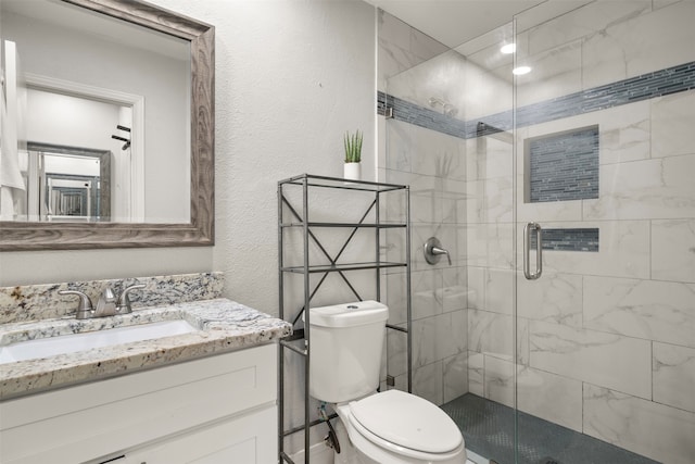 bathroom with toilet, an enclosed shower, and vanity