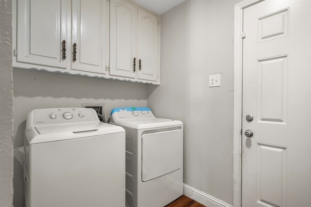 laundry area featuring cabinets, separate washer and dryer, and dark hardwood / wood-style flooring