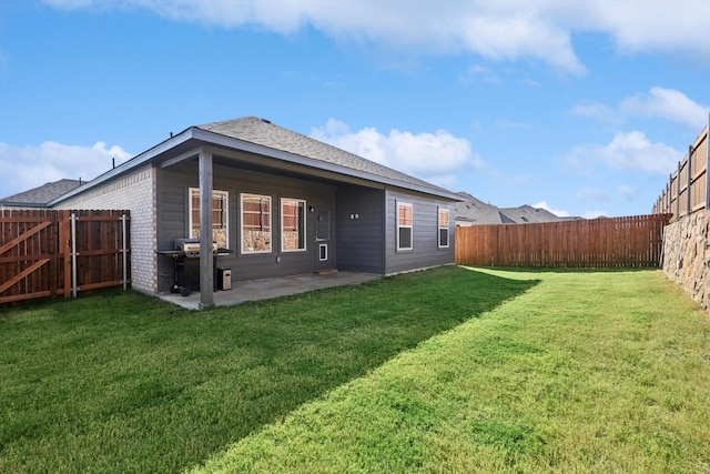 rear view of house with a patio and a lawn