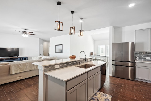 kitchen with dark hardwood / wood-style flooring, sink, gray cabinets, and stainless steel fridge