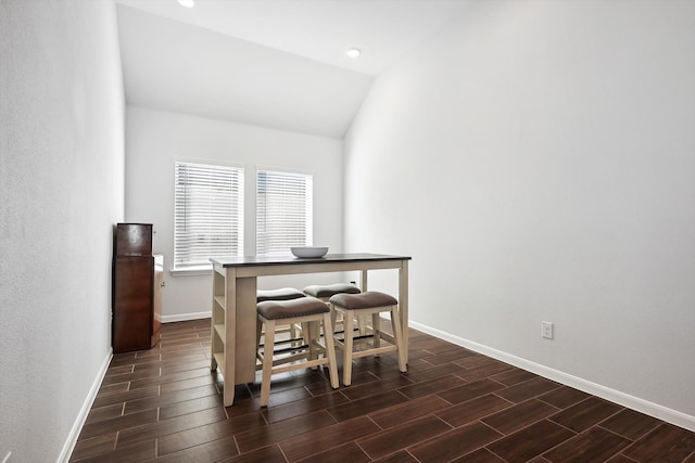 dining room featuring lofted ceiling and dark hardwood / wood-style floors