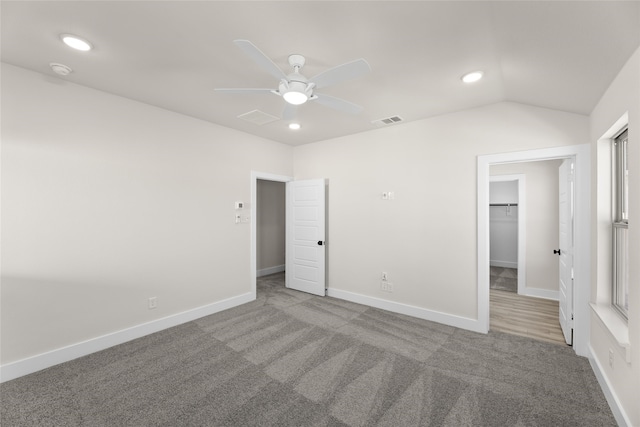 unfurnished bedroom with recessed lighting, carpet floors, visible vents, baseboards, and vaulted ceiling