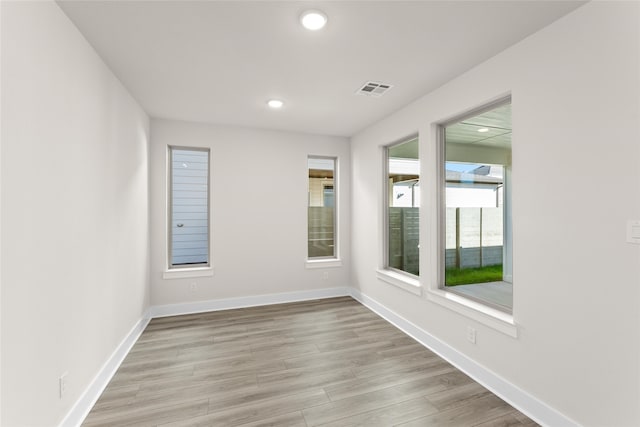 unfurnished room with recessed lighting, visible vents, baseboards, and wood finished floors