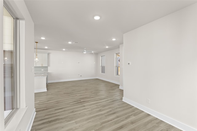 unfurnished living room with baseboards, recessed lighting, a ceiling fan, and light wood-style floors