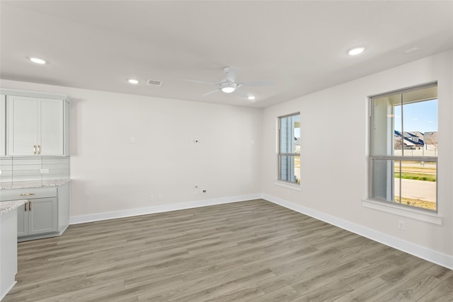 interior space with baseboards, light wood-type flooring, a wealth of natural light, and recessed lighting