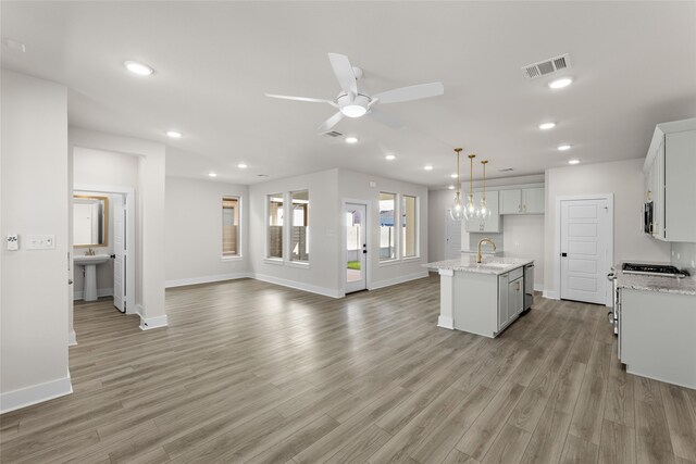 living room with a wealth of natural light, sink, and light hardwood / wood-style floors