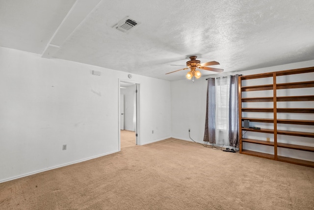 carpeted empty room featuring a textured ceiling and ceiling fan