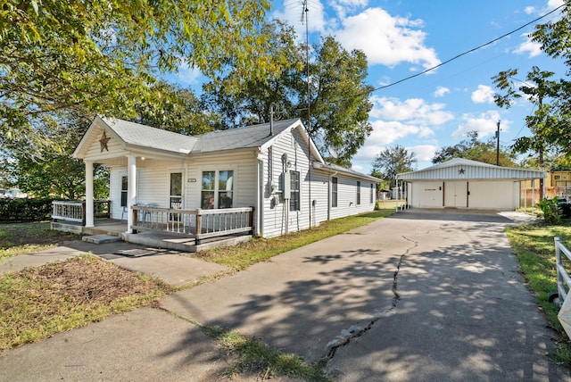 view of side of home with a garage, an outbuilding, and a porch