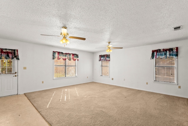 carpeted spare room featuring a textured ceiling and ceiling fan