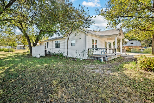 back of property featuring a deck and a lawn