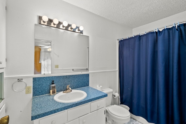 bathroom featuring toilet, backsplash, vanity, a textured ceiling, and ceiling fan