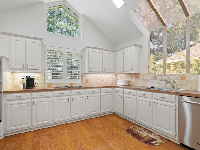 kitchen featuring light hardwood / wood-style flooring, white cabinetry, stainless steel dishwasher, and sink