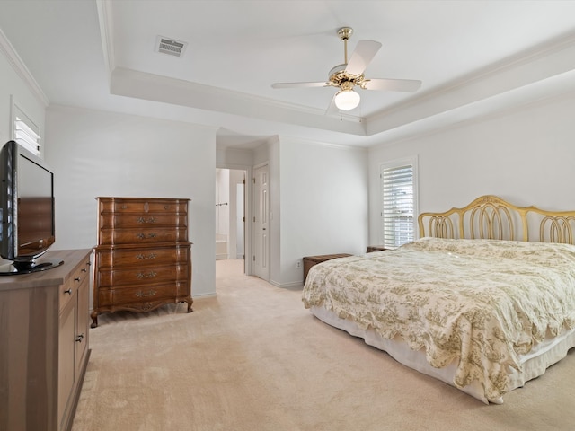 carpeted bedroom with ornamental molding, a tray ceiling, and ceiling fan