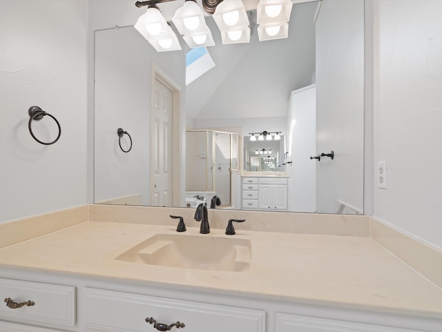 bathroom featuring vanity, lofted ceiling with skylight, and an enclosed shower