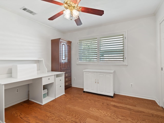 unfurnished office with ornamental molding, light wood-type flooring, and ceiling fan