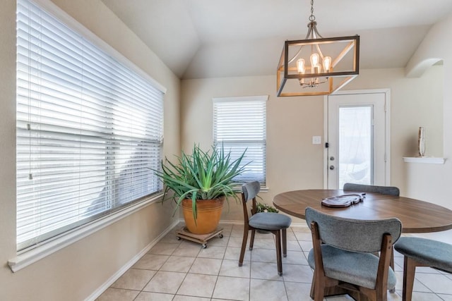 tiled dining space featuring vaulted ceiling and a chandelier