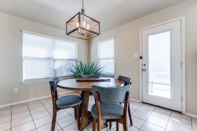 dining space with light tile patterned floors, an inviting chandelier, and a wealth of natural light