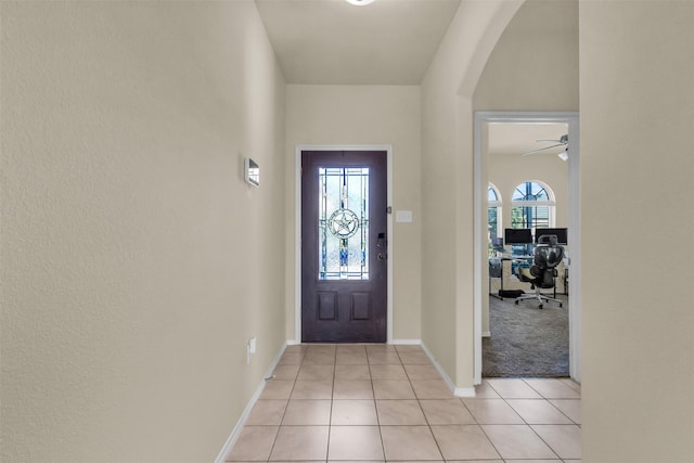 tiled entryway featuring ceiling fan and a wealth of natural light