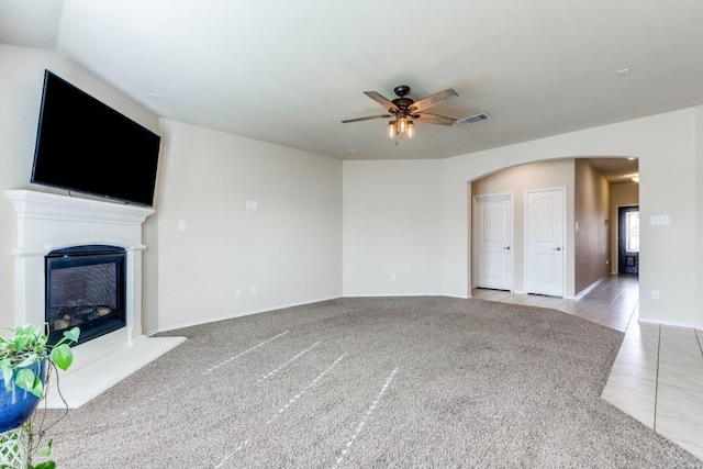 unfurnished living room featuring ceiling fan and light tile patterned floors