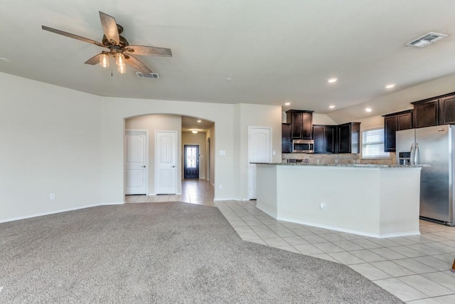 kitchen featuring light tile patterned floors, ceiling fan, stainless steel appliances, backsplash, and dark brown cabinets