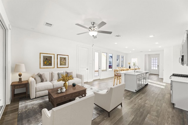 living area featuring dark wood-style floors, a ceiling fan, visible vents, and recessed lighting