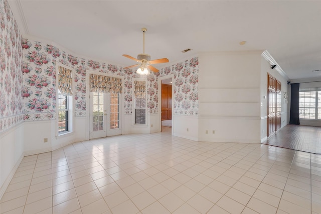 spare room with ceiling fan, a healthy amount of sunlight, light tile patterned floors, and crown molding