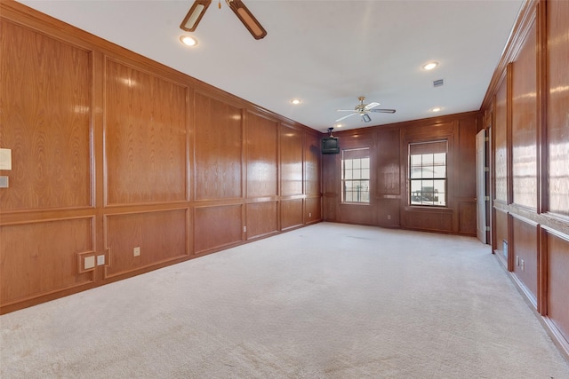 carpeted empty room with ceiling fan and ornamental molding