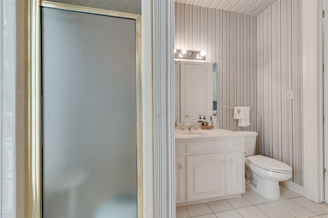 bathroom featuring tile patterned flooring, vanity, toilet, and a shower with door