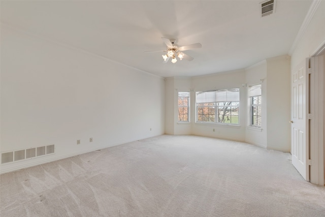 carpeted spare room with ceiling fan and crown molding