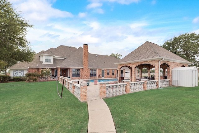 view of swimming pool featuring a yard, area for grilling, a storage shed, and a patio area