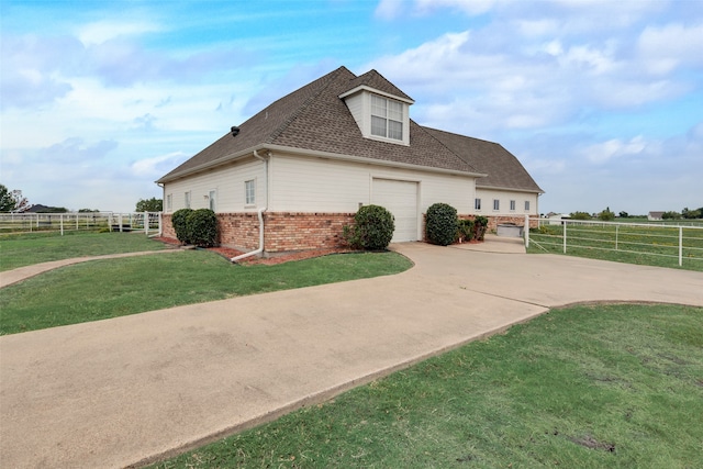 view of side of property with a rural view and a yard