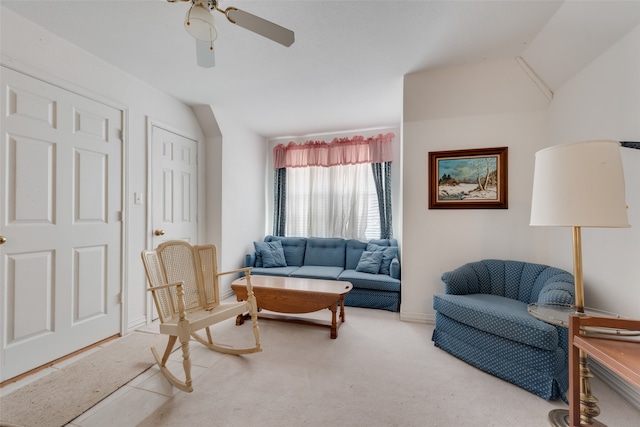 carpeted living room with ceiling fan and vaulted ceiling