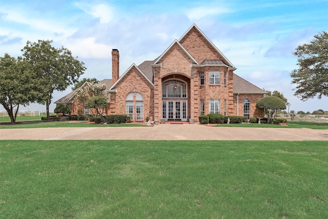 view of front of home with french doors and a front lawn