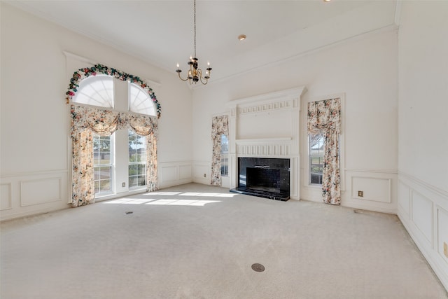 unfurnished living room with a chandelier, carpet floors, and a premium fireplace