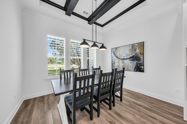 dining area with hardwood / wood-style floors, crown molding, and beamed ceiling