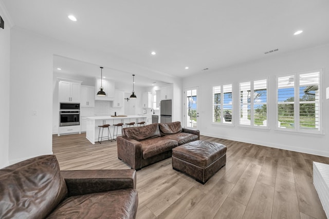 living room with light hardwood / wood-style flooring and ornamental molding