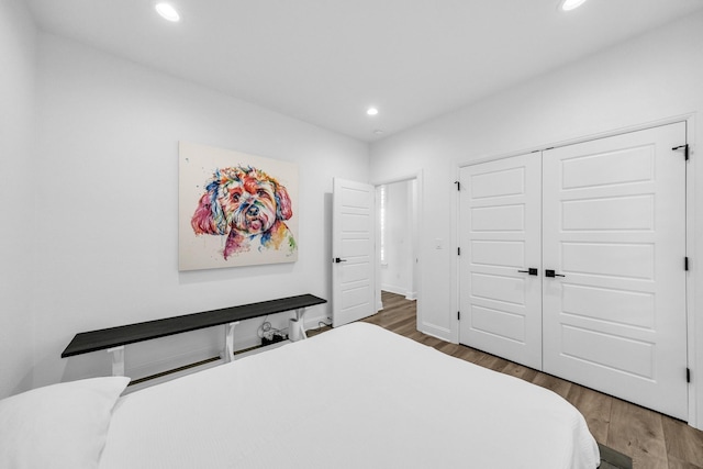 bedroom with dark hardwood / wood-style floors and a closet