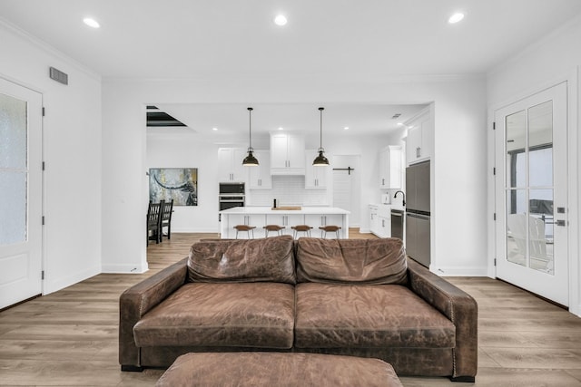 living room with light hardwood / wood-style flooring and ornamental molding