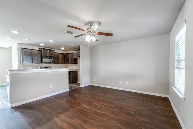 kitchen featuring ceiling fan, dark brown cabinets, a wealth of natural light, and dark hardwood / wood-style flooring