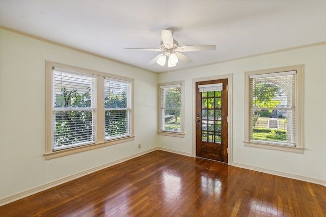 unfurnished room featuring a wealth of natural light, crown molding, dark hardwood / wood-style floors, and ceiling fan