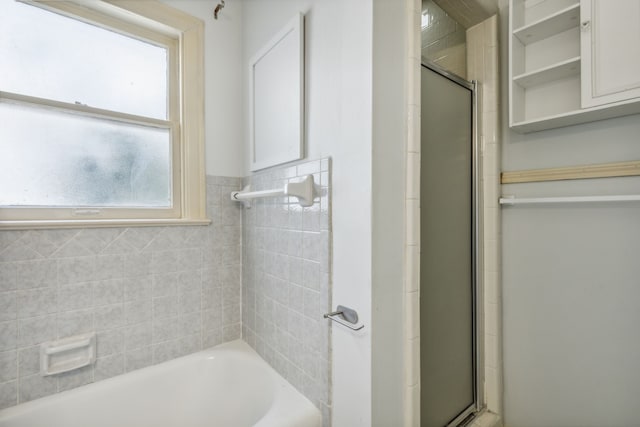 bathroom featuring tile walls and separate shower and tub