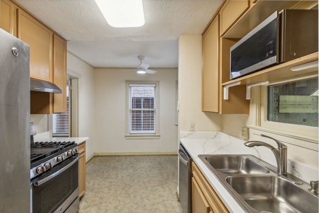 kitchen featuring light carpet, sink, appliances with stainless steel finishes, a textured ceiling, and ceiling fan