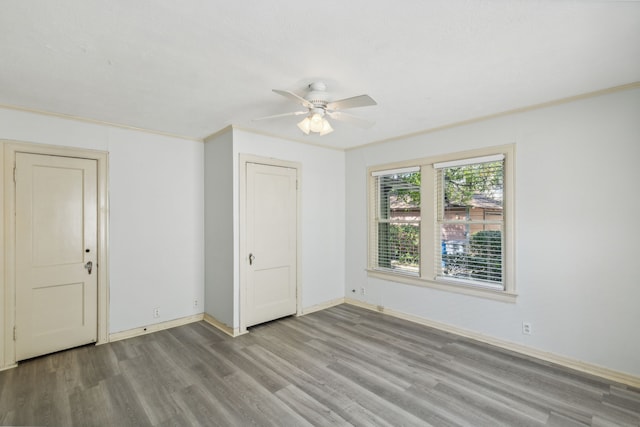 empty room with light hardwood / wood-style floors, crown molding, and ceiling fan