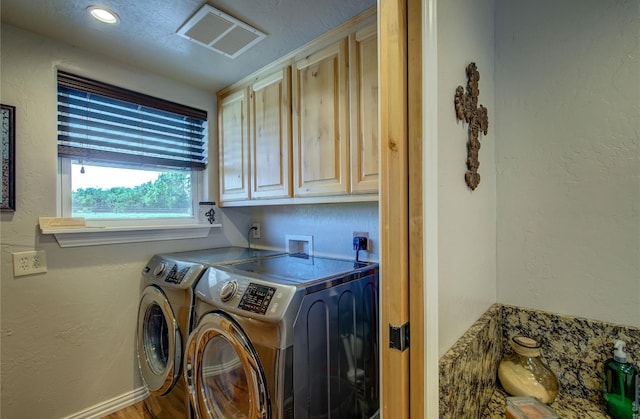 laundry area with cabinets, hardwood / wood-style flooring, and washing machine and dryer