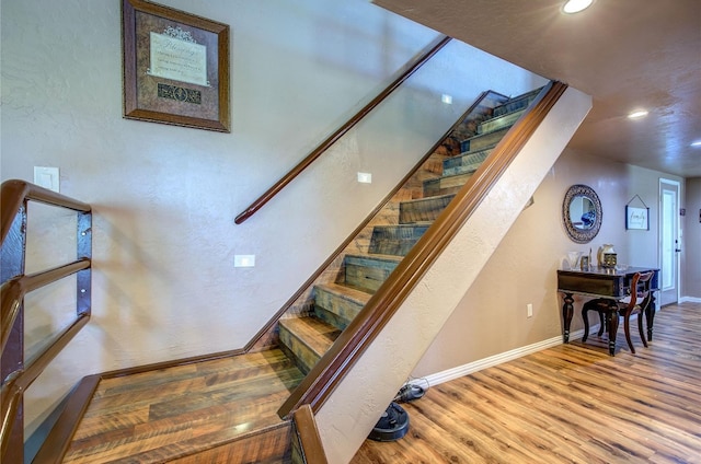 stairs featuring hardwood / wood-style flooring