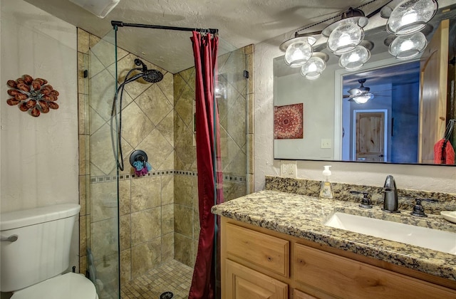 bathroom with a textured ceiling, toilet, ceiling fan, walk in shower, and vanity