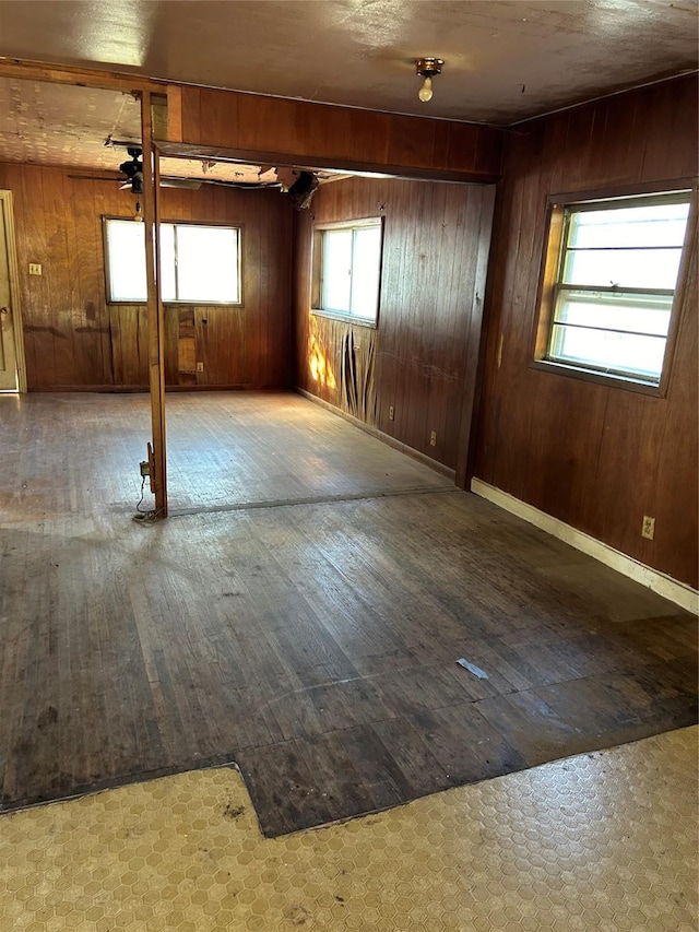 unfurnished room with hardwood / wood-style floors and wooden walls