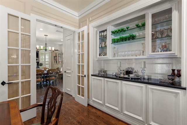 bar with french doors, dark wood-type flooring, pendant lighting, a chandelier, and white cabinetry